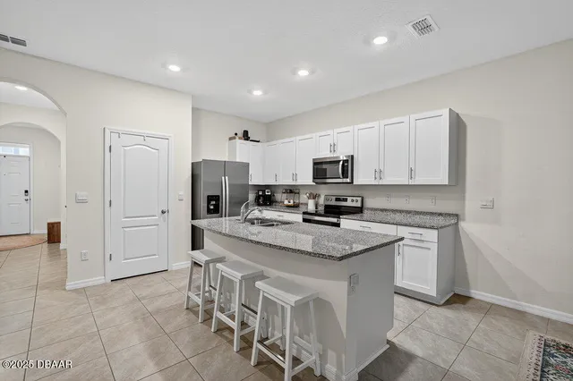 a kitchen with white cabinets appliances and a counter top space