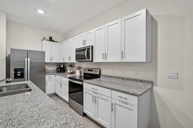 a kitchen with white cabinets and stainless steel appliances