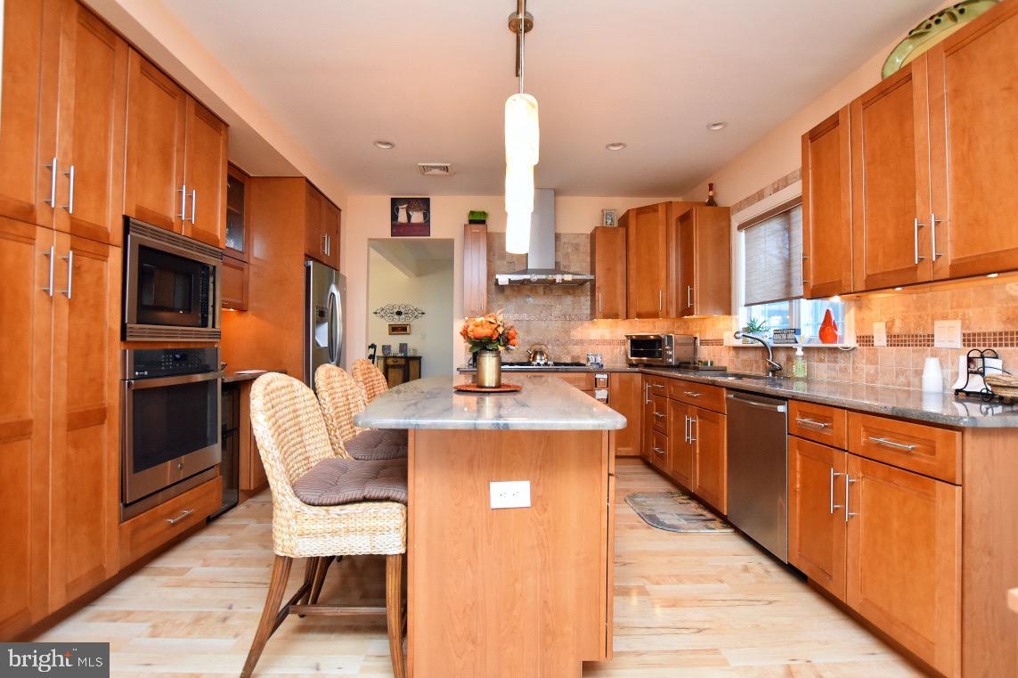 1023 Prospect Ridge Boulevard Haddon Heights, NJ 08035 - Photo 14 of 44 a kitchen with stainless steel appliances kitchen island granite countertop a refrigerator a stove and a wooden cabinets