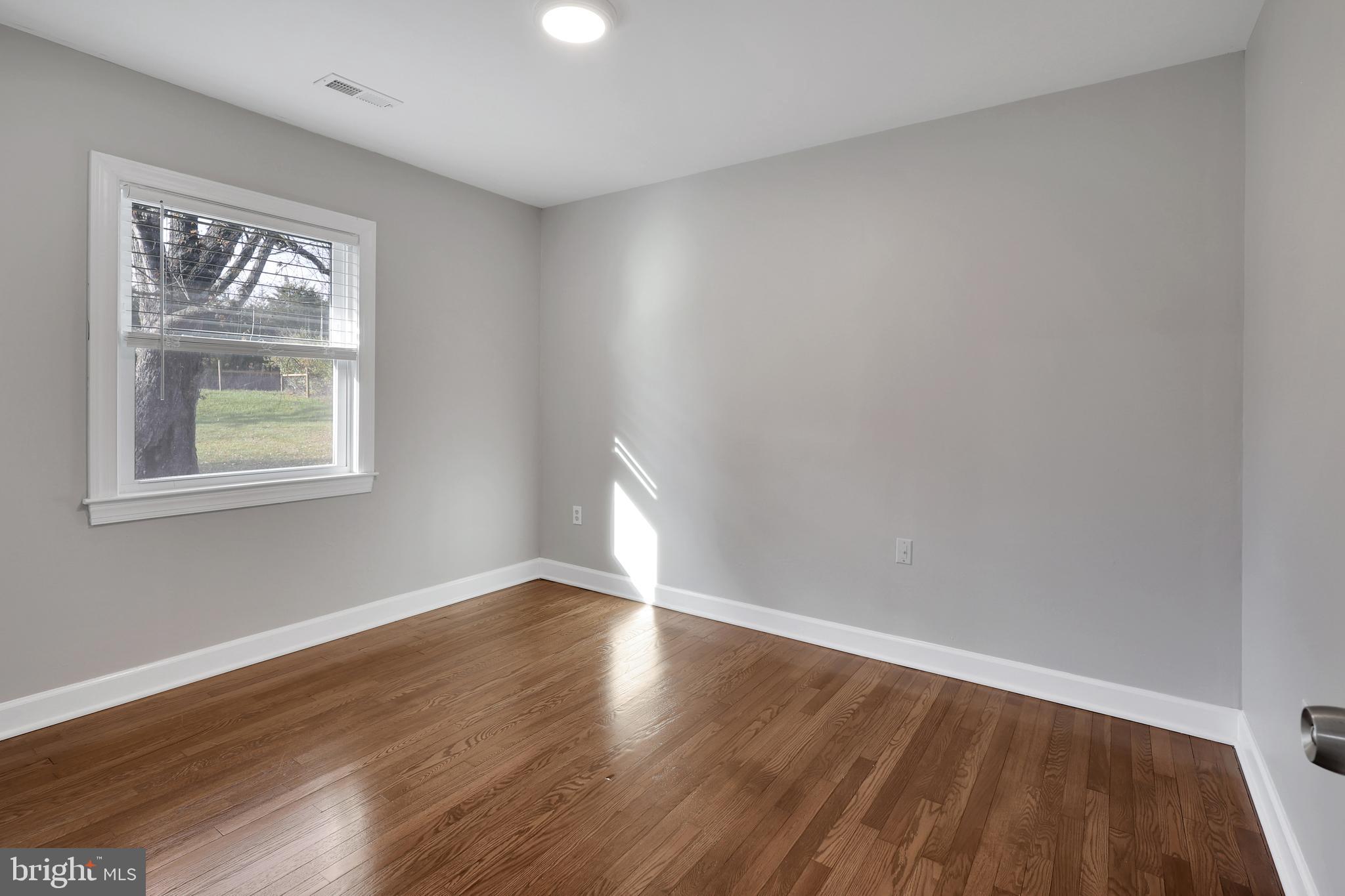 258 Martin Payne Road Kearneysville, WV 25430 - Photo 12 of 35 a view of an empty room with wooden floor and a window