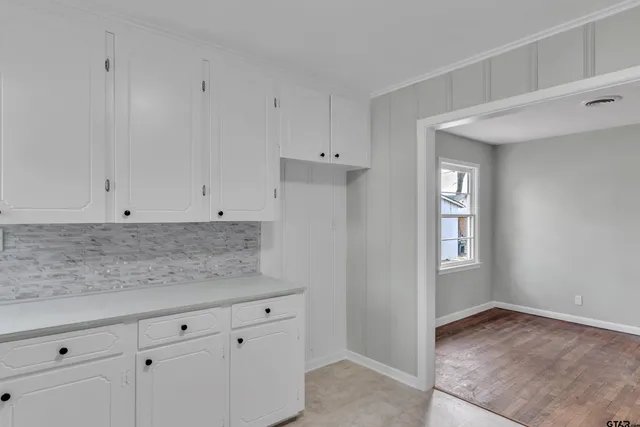 a view white cabinets with granite countertop white cabinets and a window