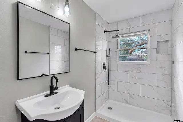 a bathroom with a shower a mirror and a sink