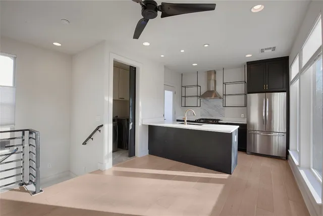 a kitchen with stainless steel appliances kitchen island a refrigerator sink and stove