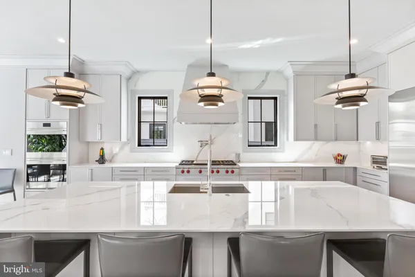 a kitchen with kitchen island granite countertop a stove a sink a dining table and chairs