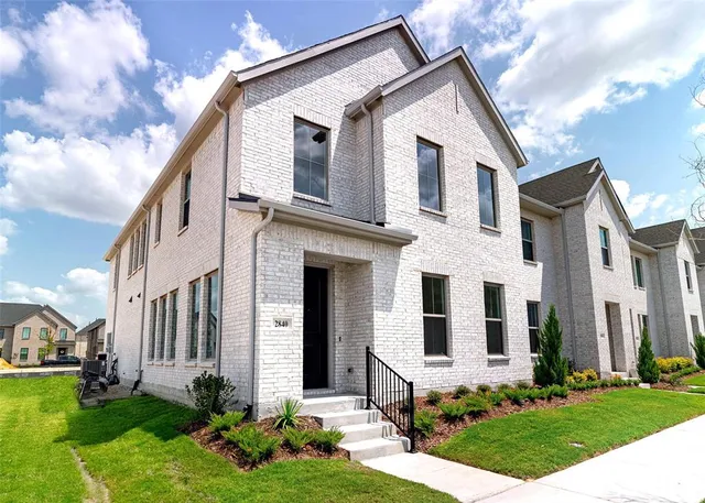 a front view of a house with yard and green space