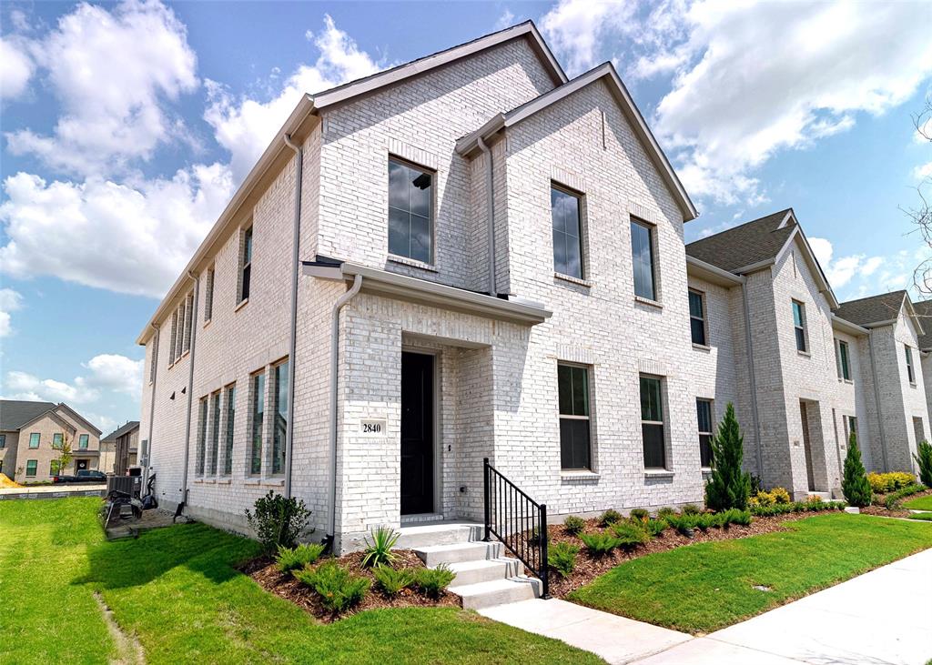 a front view of a house with yard and green space