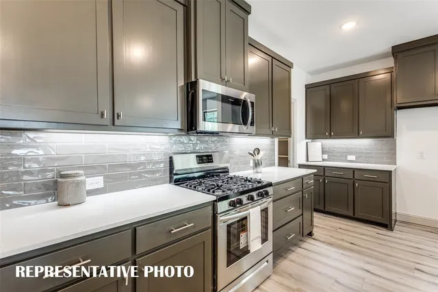 a kitchen with a sink cabinets and wooden floor