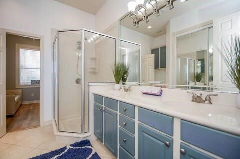168 Lake Point Boulevard, Unit A102 Conroe, TX 77356 - Photo 7 of 7 a bathroom with a double vanity sink a mirror and a shower