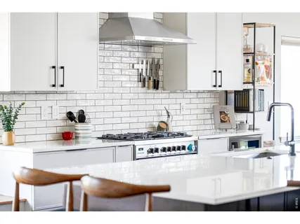a kitchen with a dining table chairs and white cabinets
