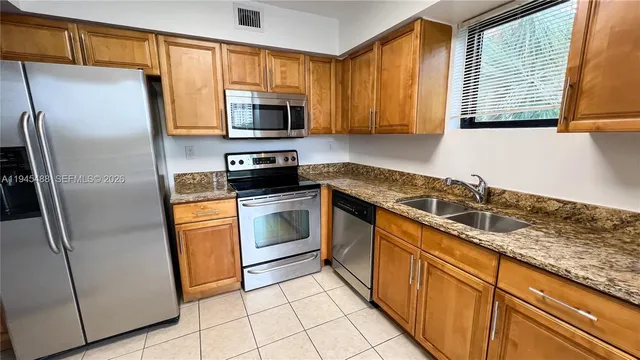 a kitchen with stainless steel appliances granite countertop a refrigerator sink and stove