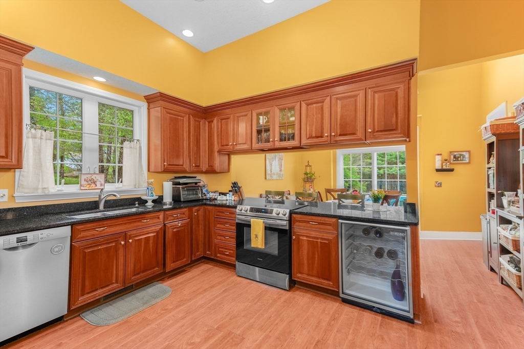 113 Greenwich Plains Road Ware, MA 01082 - Photo 8 of 42 a kitchen with stainless steel appliances granite countertop wooden cabinets a sink dishwasher a stove and a refrigerator with wooden floor