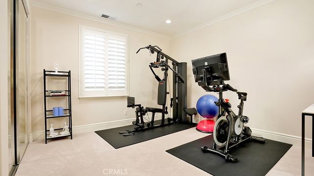 a spacious bedroom with a bed a couch and a chandelier