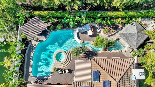 a view of a patio with table and chairs potted plants and a large tree