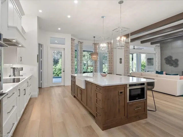 a large kitchen with stainless steel appliances granite countertop a lot of counter space and wooden floors