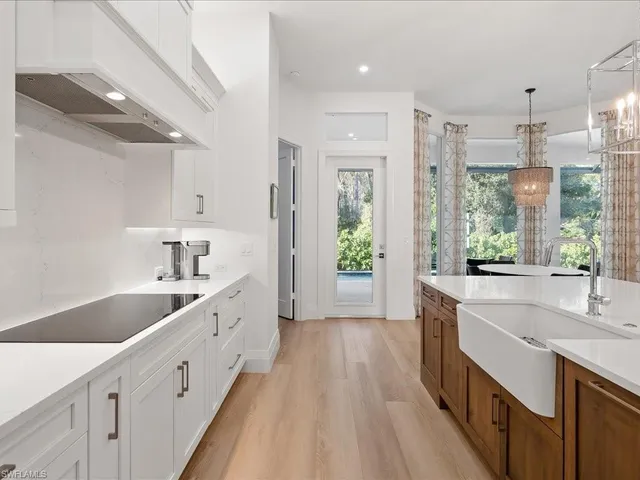 a large kitchen with a lot of counter space and wooden floor