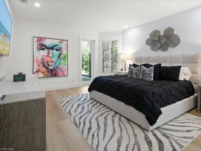 a bedroom with a large bed and a painting on the wall