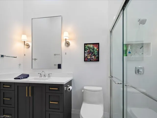 a bathroom with a sink a toilet and shower