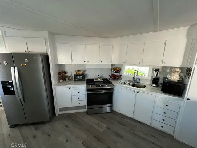 a kitchen with white cabinets and stainless steel appliances