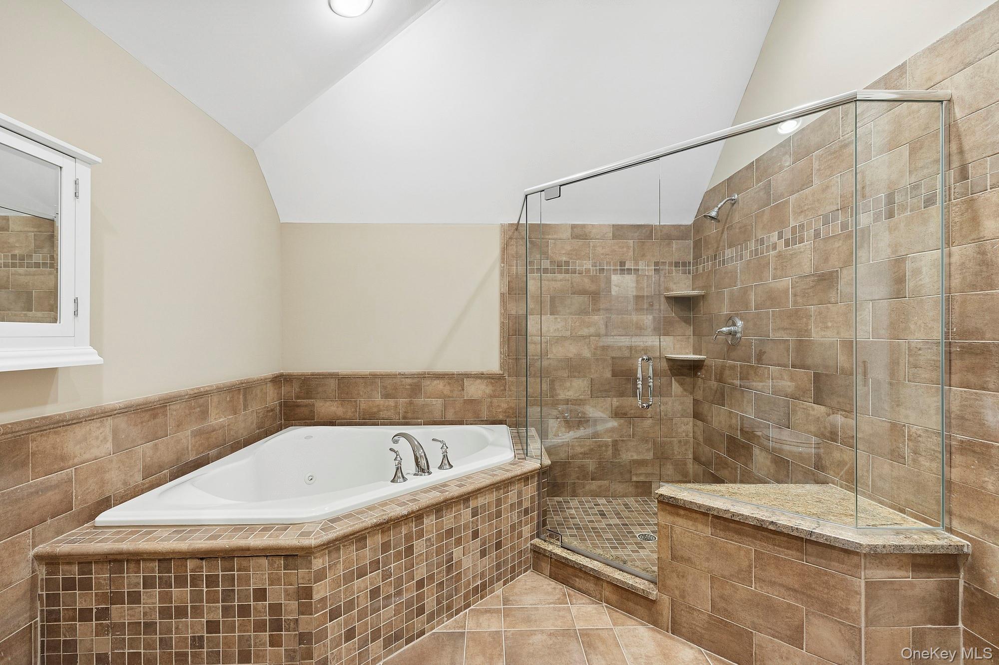 144 Round Swamp Road West Hills, NY 11743 - Photo 31 of 39 Bathroom featuring a bath, vaulted ceiling, light tile patterned floors, and a stall shower