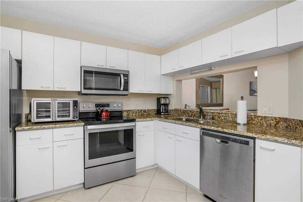 7754 Emerald Circle, Unit T202 Naples, FL 34109 - Photo 11 of 22 a kitchen with a sink stove and microwave