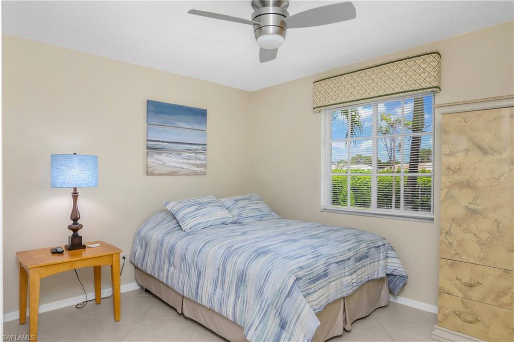 7754 Emerald Circle, Unit T202 Naples, FL 34109 - Photo 17 of 22 a bedroom with a bed and a window
