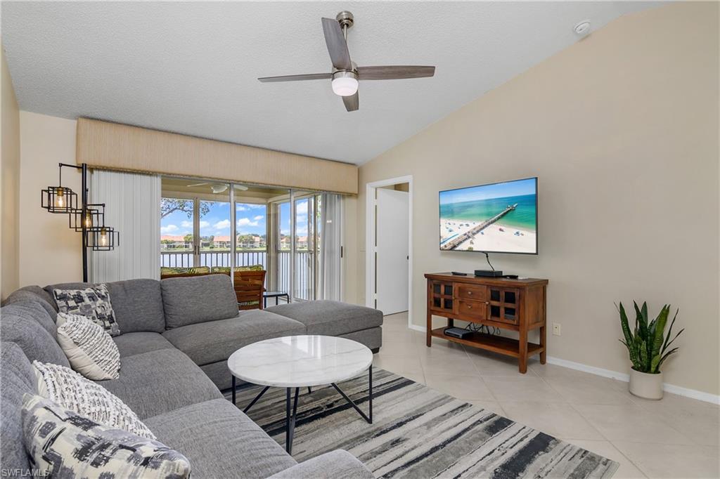 7754 Emerald Circle, Unit T202 Naples, FL 34109 - Photo 7 of 22 a living room with furniture a rug and a flat screen tv