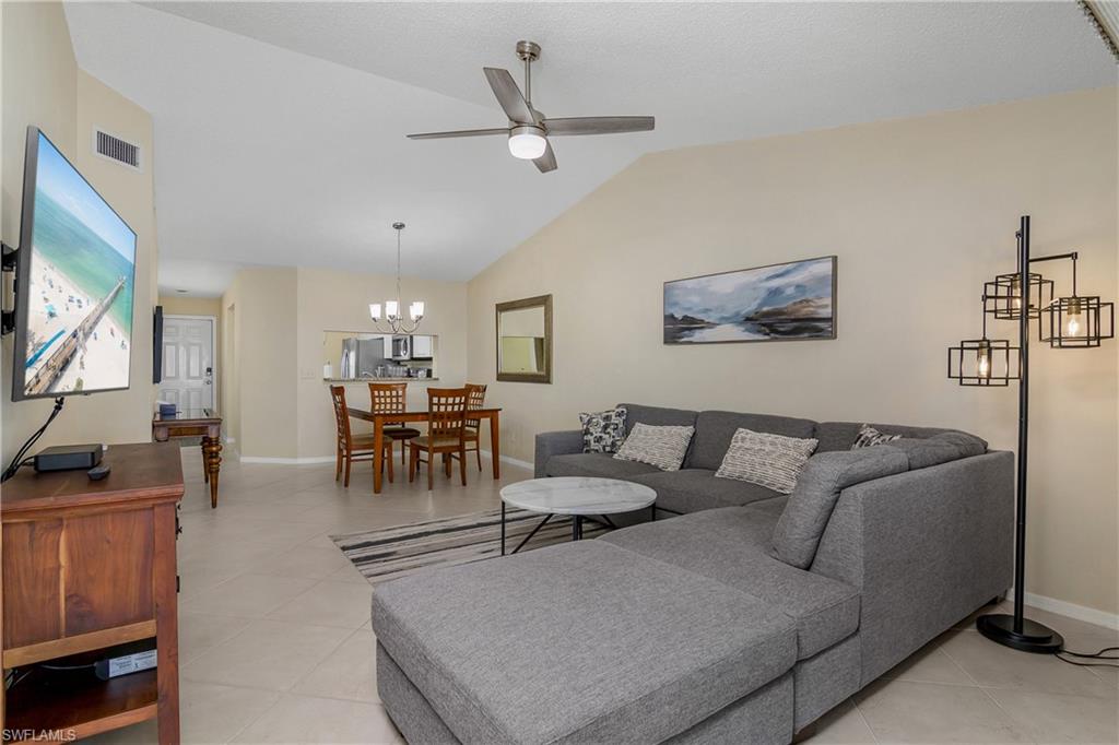 7754 Emerald Circle, Unit T202 Naples, FL 34109 - Photo 8 of 22 a living room with furniture and a flat screen tv