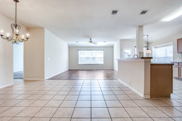 a view of an empty room and kitchen view