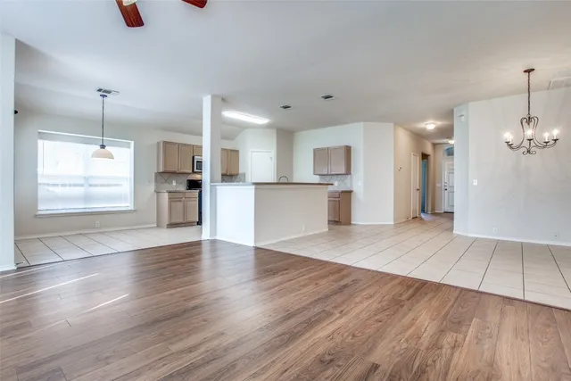 a view of a kitchen with a fridge and wooden floor