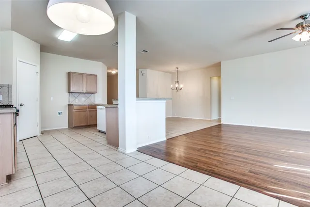 a view of a kitchen with a sink and an empty room