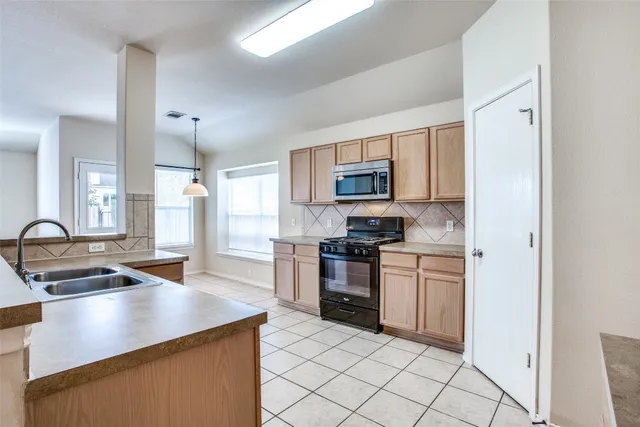 a kitchen with kitchen island granite countertop a sink appliances and cabinets