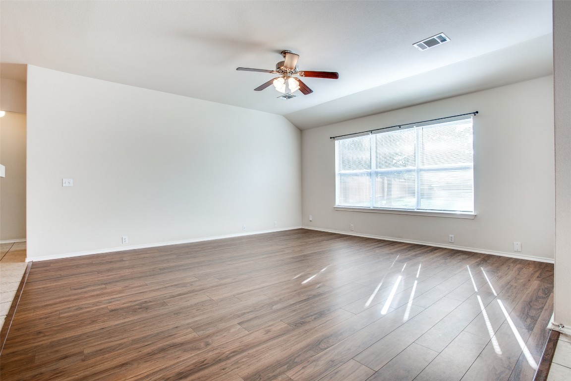 Undisclosed Address Round Rock, TX 78665 - Photo 10 of 25 an empty room with wooden floor ceiling fan and windows