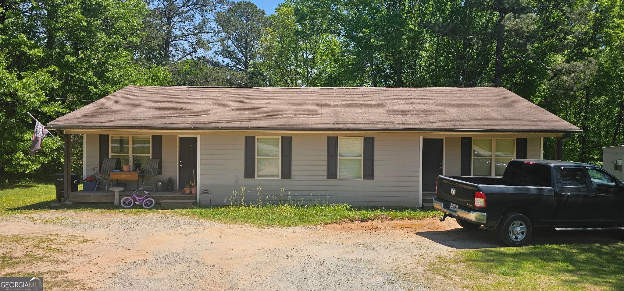 a front view of a house with a yard and potted plants