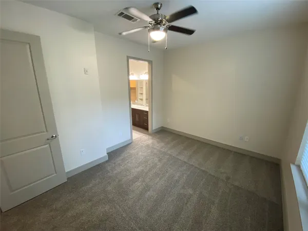 an empty room with closet and windows