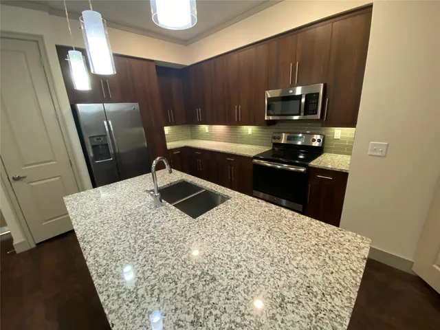 a kitchen with stainless steel appliances wooden cabinets a refrigerator and a sink