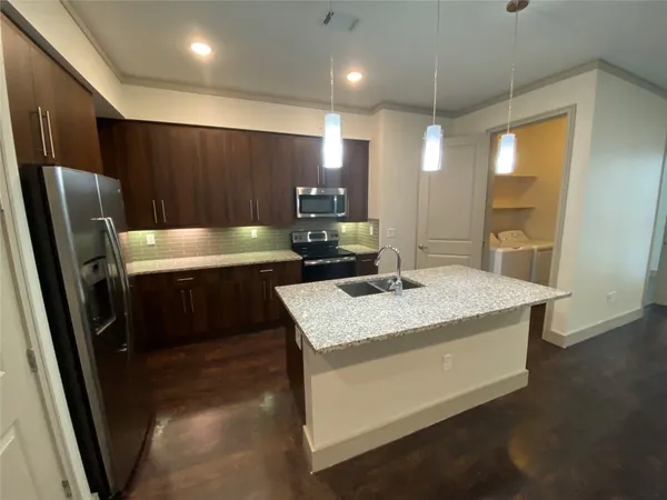 a kitchen with a sink a refrigerator and a stove