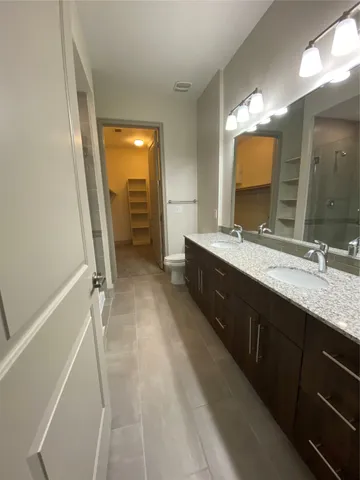 a spacious bathroom with a double vanity sink a mirror and a shower