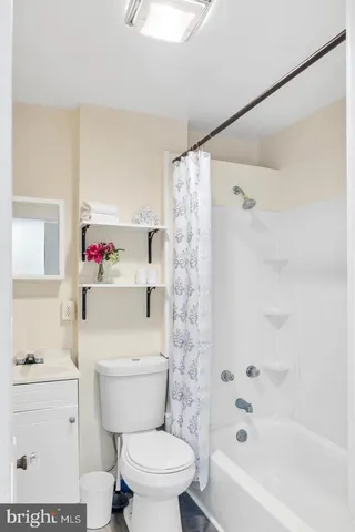 a white toilet sitting next to a bath tub