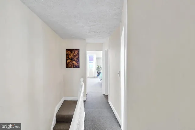 a view of a hallway with wooden floor and closet