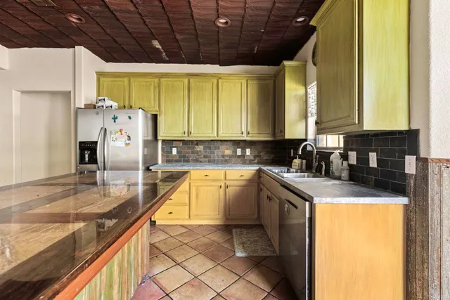 a kitchen with granite countertop a sink a counter top space appliances and cabinets