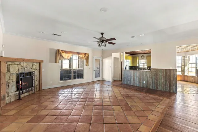 a view of a livingroom with wooden floor and a kitchen