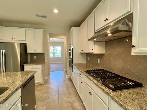 a kitchen with stainless steel appliances a sink a stove and cabinets