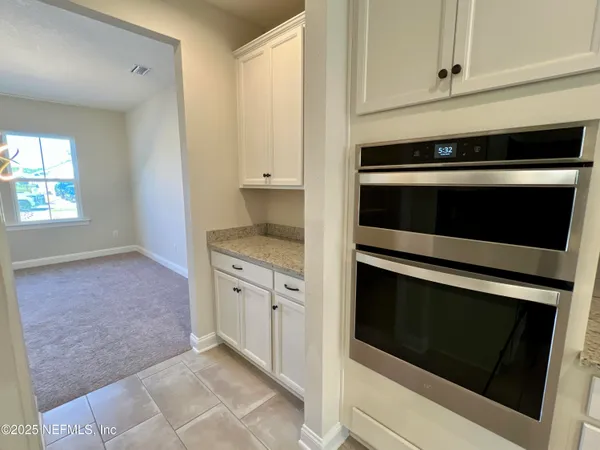 a kitchen with granite countertop white cabinets appliances and a sink