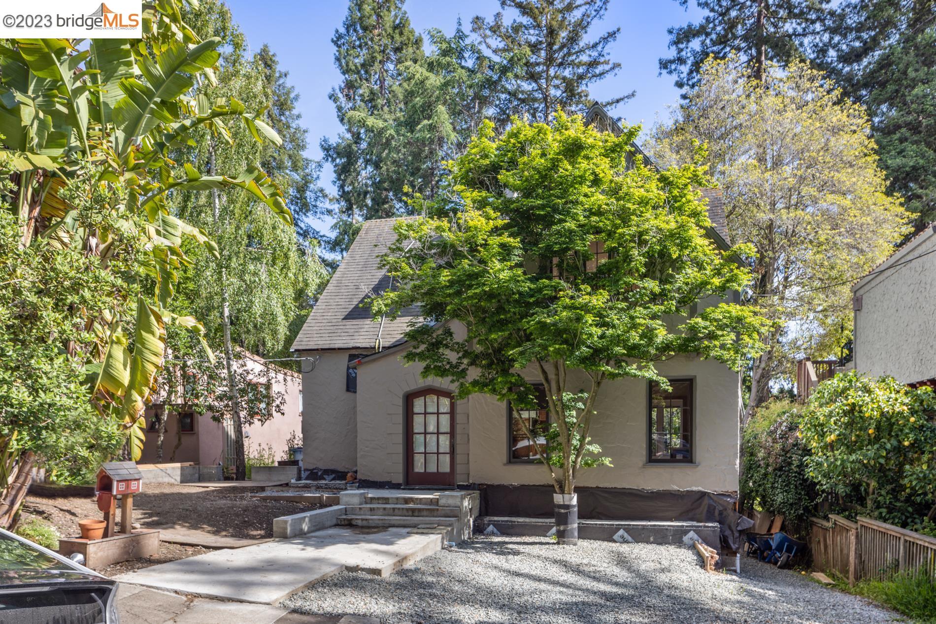a front view of a house with a tree