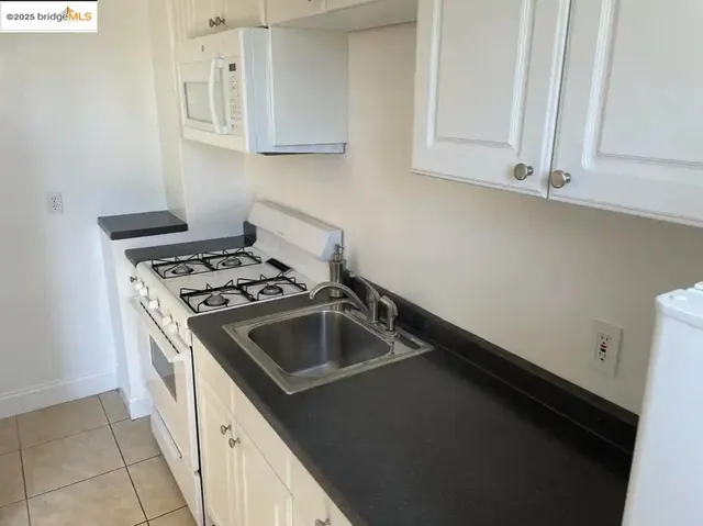 a kitchen with white cabinets and white appliances