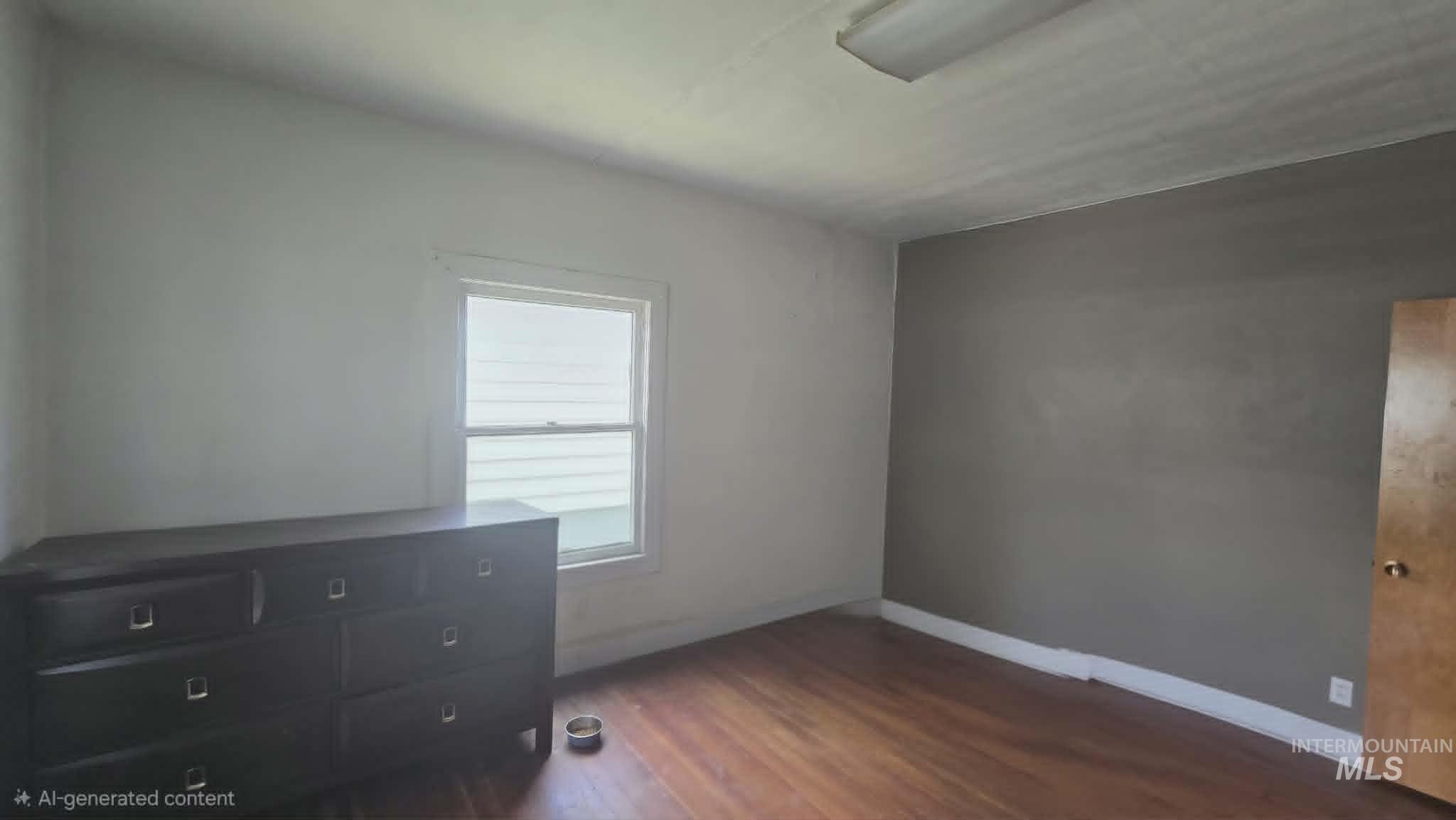 1212 Main Street Pomeroy, WA 99347 - Photo 11 of 18 Room featuring wood-finish flooring, a neutral color palette, white trim, and a double-hung window