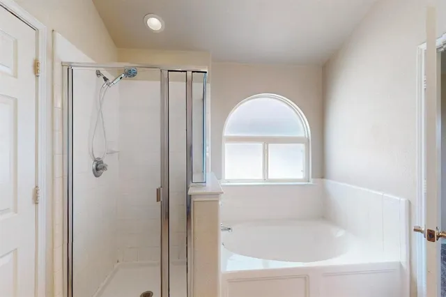 a white bath tub sitting next to a shower
