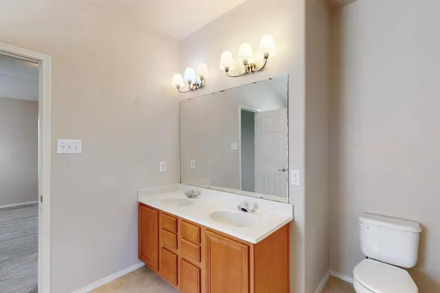 a bathroom with a sink a toilet and mirror