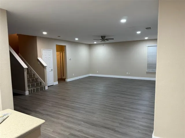 an empty room with wooden floor and entryway
