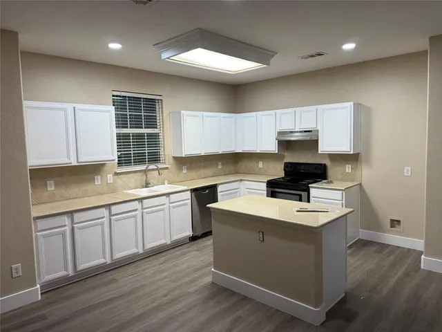 a kitchen with a sink stove and cabinets